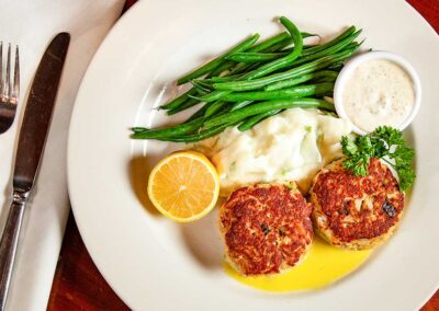 Crabcakes with green beans and mashed potatoes on fine dinnerware